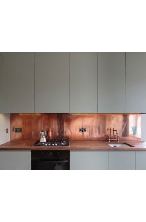 The copper splashbacks are installed at the kitchen counter